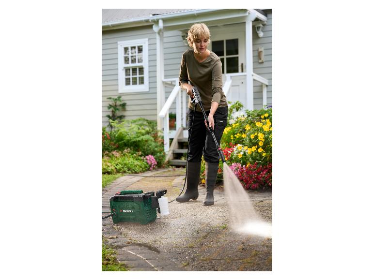 Femme nettoyant une allée avec un nettoyeur haute pression Parkside.