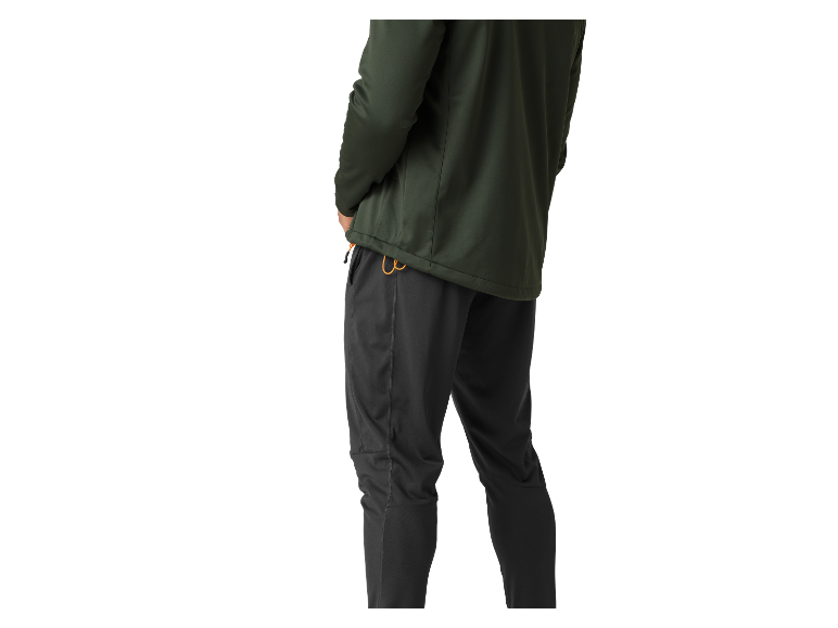 Homme portant une veste verte et un pantalon de sport gris.