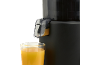 Extracteur de jus versant du jus d'orange dans un verre.