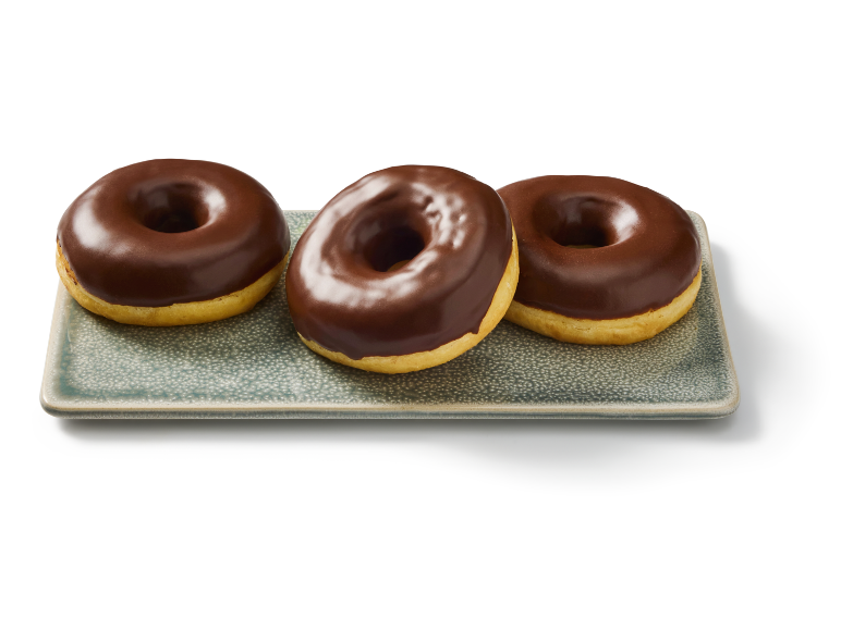 Trois beignets glacés au chocolat sur un plateau rectangulaire.