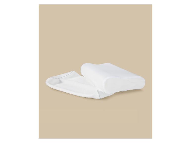 Oreiller ergonomique blanc et sa housse sur fond beige.