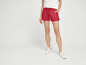 Une femme portant un short rouge et des baskets blanches.