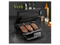 Des steaks grillés sur un grill noir avec une minuterie digitale.