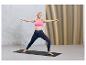 Une femme en tenue de sport fait du yoga sur un tapis.