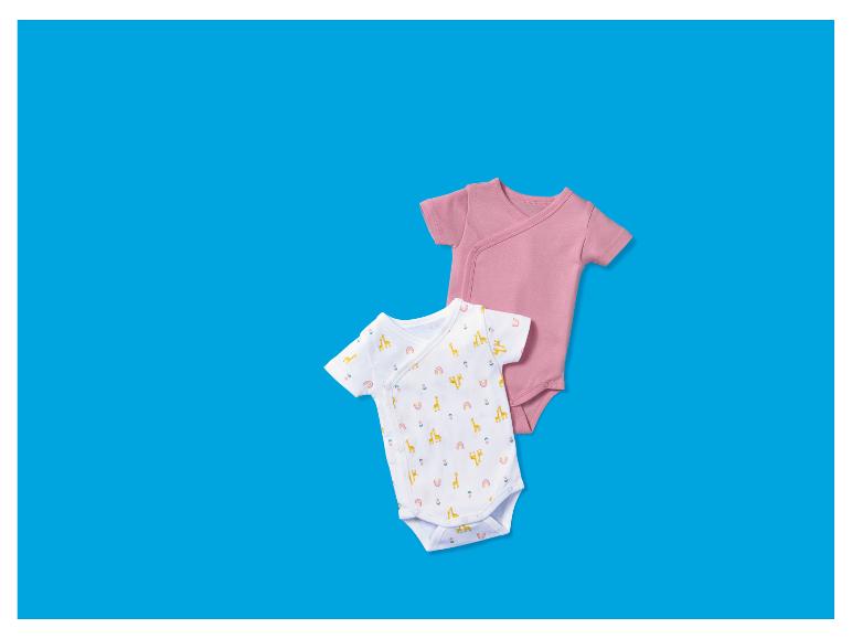 Deux bodys pour bébé, un rose uni et un blanc à motif girafe.