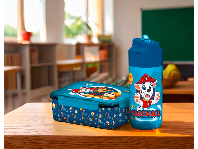 Boîte à lunch et gourde Paw Patrol sur une table en bois.