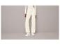 Pantalon de survêtement blanc et baskets blanches.