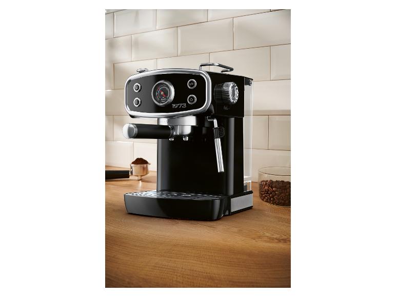 Machine à expresso noire sur un comptoir en bois avec grains de café et café moulu