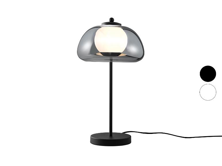Lampe de table avec abat-jour en verre fumé et base noire, avec options de couleur.