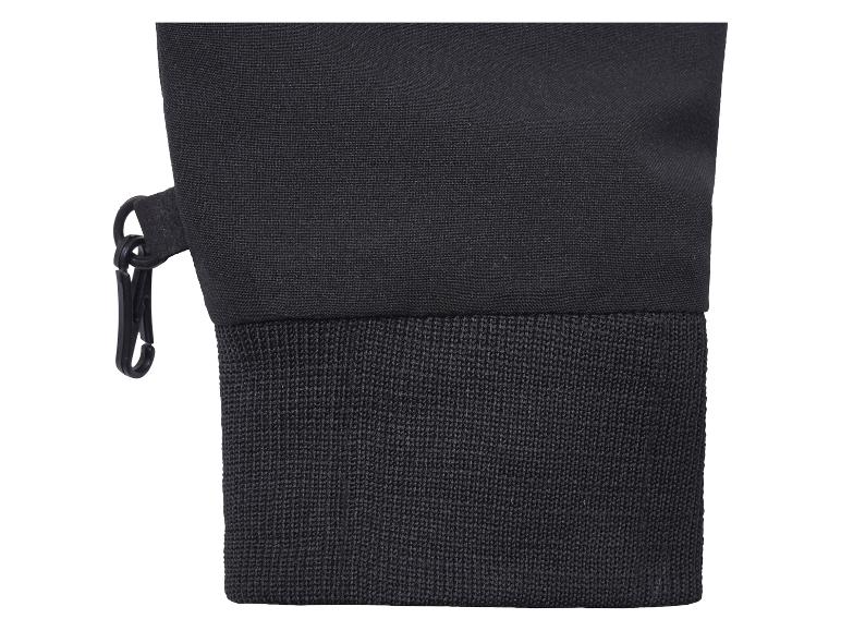 Gros plan d'une manche textile noire avec poignet côtelé et clip en plastique