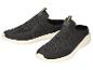 Une paire de chaussures de sport noires sans lacets avec des accents verts et des semelles blanches.
