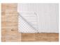 Protège-matelas blanc avec fermeture éclair sur sol en bois.