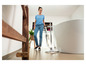 Une femme nettoie le sol d'une salle de bain avec une nettoyeuse vapeur Karcher.