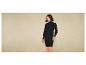 Une femme porte une robe noire en tricot.