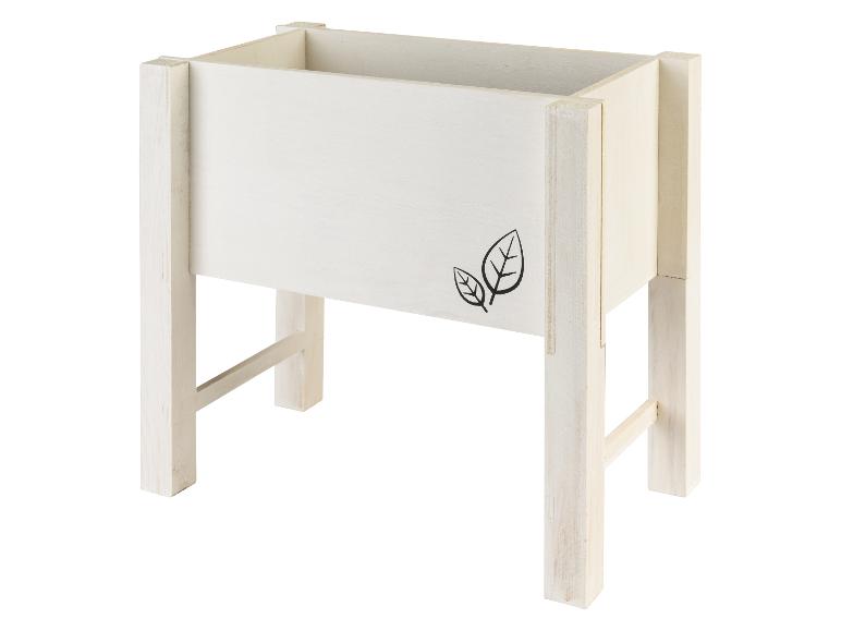 Jardinière en bois blanche avec des pieds.