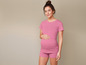 Une femme enceinte portant un t-shirt rose et un short.
