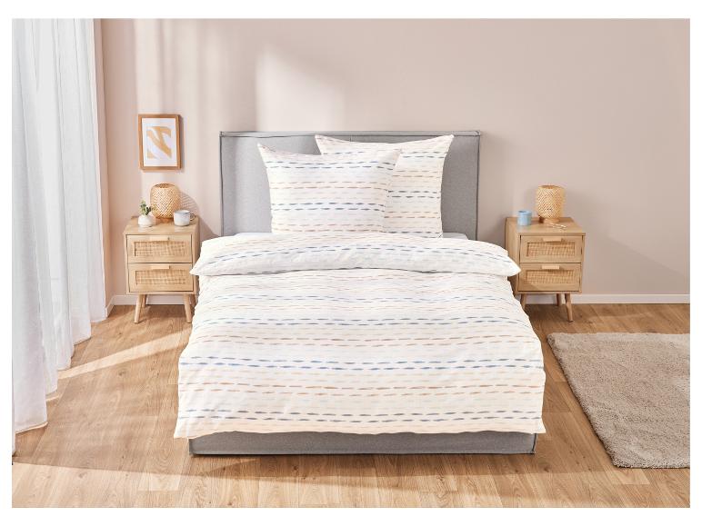 Parure de lit et coussins rayés, style minimaliste.
