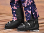 Des chaussures de ski noires avec un pantalon de ski tie-dye