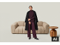 Femme en pull bordeaux, pantalon et manteau noir, debout près d'un canapé beige.