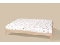 Drap-housse blanc à cœurs rouges sur un cadre de lit en bois.