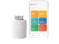 Un thermostat intelligent blanc et une application smartphone pour la gestion de la maison.