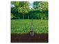 Bêche de jardin plantée dans le sol avec de l'herbe et des arbres en arrière-plan.