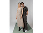 Une femme en robe beige et un homme en polo vert et pantalon.