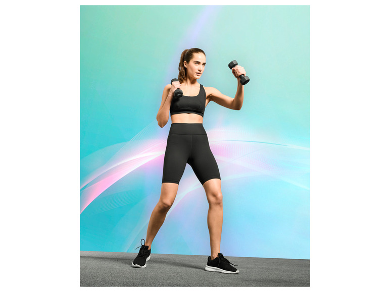 Une femme en tenue de sport avec des haltères dans les mains