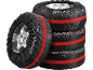 Quatre housses de pneu noires avec des sangles rouges, une appuyée contre une pile de trois.