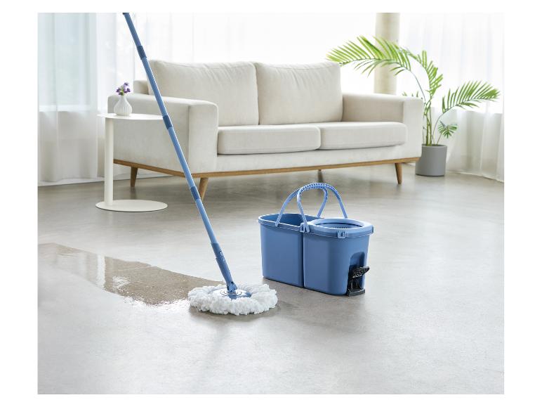 Serpillère rotative et seau nettoyant un sol dans un salon