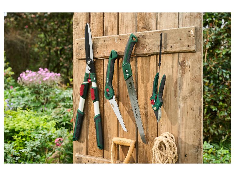 Outils de jardin PARKSIDE: taille-haies, scies pliantes et sécateurs sur une clôture en bois.