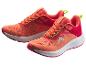 Une paire de chaussures de sport orange et rouges avec des accents verts.