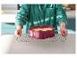 Personne tenant une grille de refroidissement avec un gâteau en forme de cœur dans un moule en silicone.