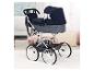 Poussette de poupée bleue avec roues blanches et sac assorti dans une chambre d'enfant.