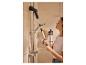 Femme nettoyant les carreaux de douche avec une brosse électrique télescopique.