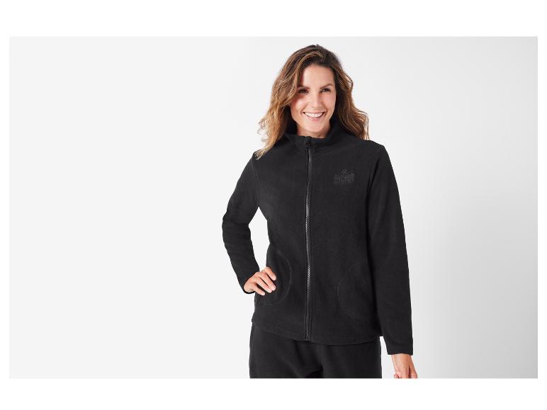 Une femme portant une veste en polaire noire zippée de la marque 'US Grand'.