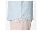 Chemise en lin bleu clair et pantalon en lin beige.