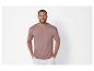 Homme portant un t-shirt rose et un pantalon blanc.