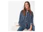 Une femme porte une chemise en jean et un jean.