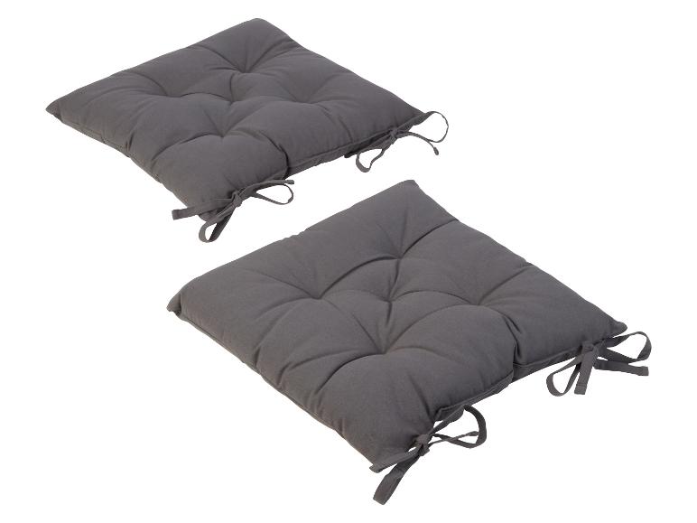 Deux coussins gris avec des boutons et des nœuds.