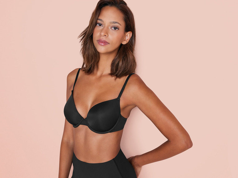 Une femme porte un soutien-gorge noir et une culotte taille haute.