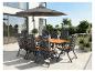 Ensemble de salle à manger d'extérieur avec table en bois, chaises pliantes et parasol sur une terrasse.