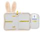 Trousse rose ouverte avec des oreilles de lapin, des élastiques dorés et une étiquette d'information.