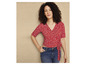 Une femme portant une chemise rouge à fleurs et un jean.