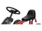 Un chariot rouge pour enfants avec un volant et un siège noirs.