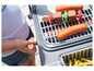 Un enfant joue avec un barbecue en jouet avec des saucisses et des frites.