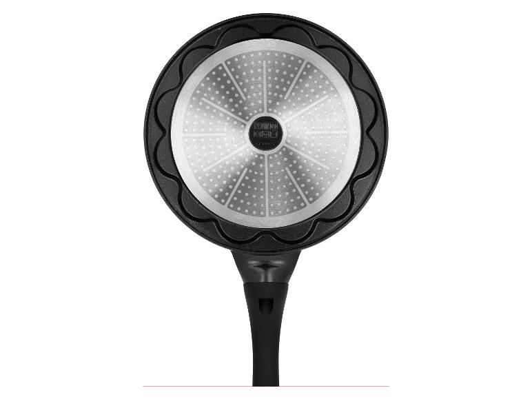 Fond d'une poêle noire avec un motif argenté et une poignée.