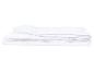 Couette blanche matelassée pliée sur fond blanc.
