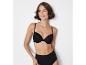 Une femme porte un soutien-gorge noir et une culotte haute.
