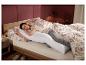 Femme dormant confortablement dans son lit avec le traversin d'allaitement LIVARNO home.